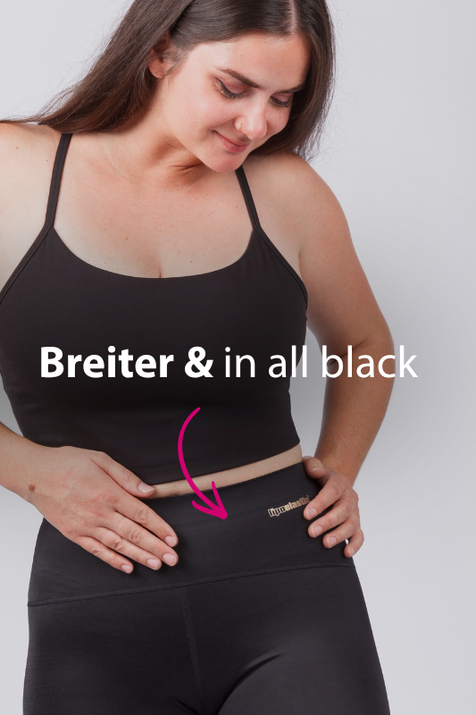 Frau trägt schwarze ACTIVE leggings 2.0 von LIPOELASTIC mit breitem, anatomisch geformtem Bund; Detailansicht der neuen Bundausführung.