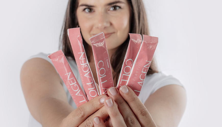 Sylvie, unsere Lipödem-Heldin hält mehrere LIPOELASTIC Collagen Beutel in der Hand und hält diese in die Kamera