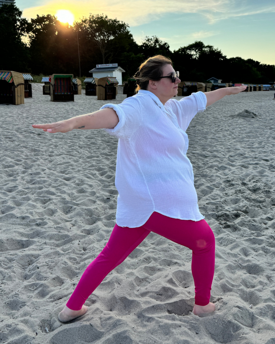Lipödem Heldin Lyn trägt die ACTIVE leggings von LIPOELASTIC in pink & macht eine Yoga Pose am Strand