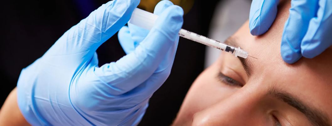Mann wird Botox in die Stirn verabreicht